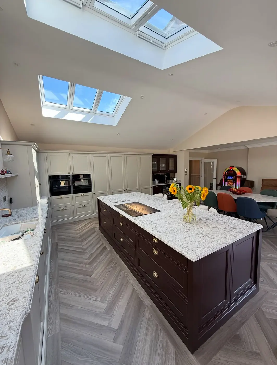 Kitchen island under vaulted skylights in an open-plan room