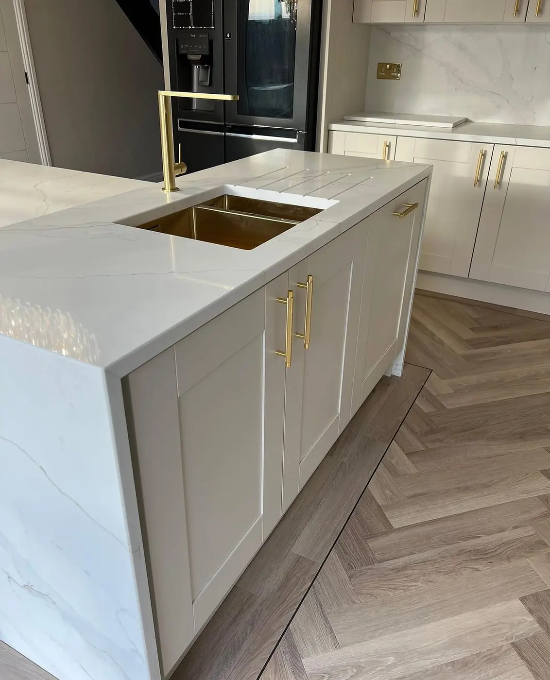 Marble-effect island with brass sink and gold tap